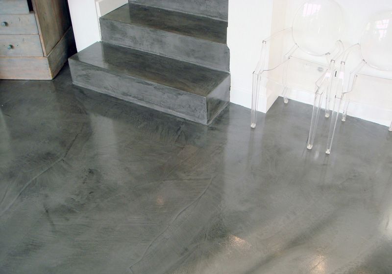Ein Betonboden mit Treppen und einem Tisch in einem Raum.