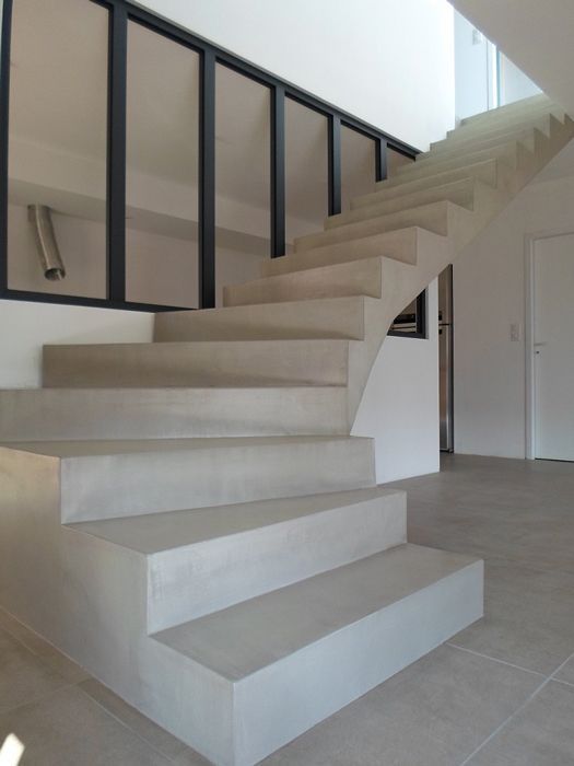 Eine weiße Treppe mit einem schwarzen Geländer in einem Raum