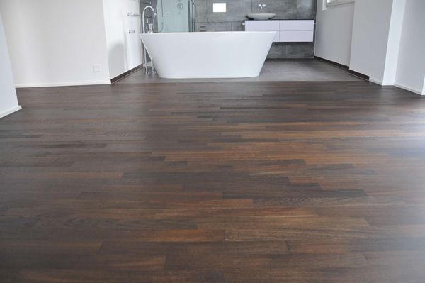 Ein Badezimmer mit Badewanne und Holzboden.