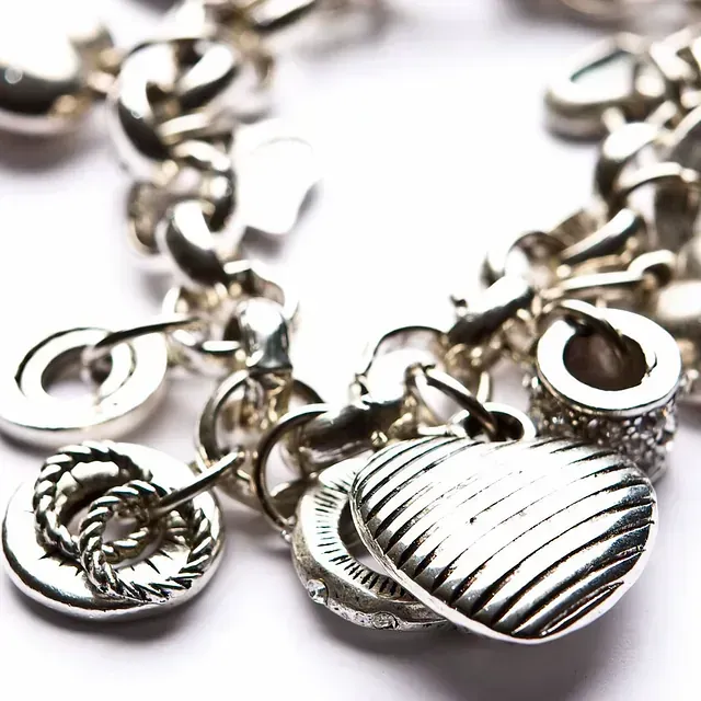 Un primer plano de una pulsera de plata con un dije en forma de corazón.