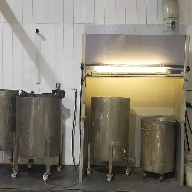 Una fila de tanques de acero inoxidable están alineados en una habitación.