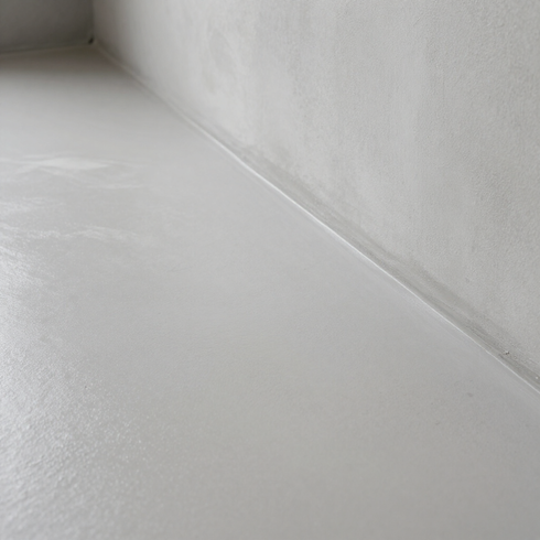 Rincón minimalista blanco de una habitación con paredes y suelo lisos.