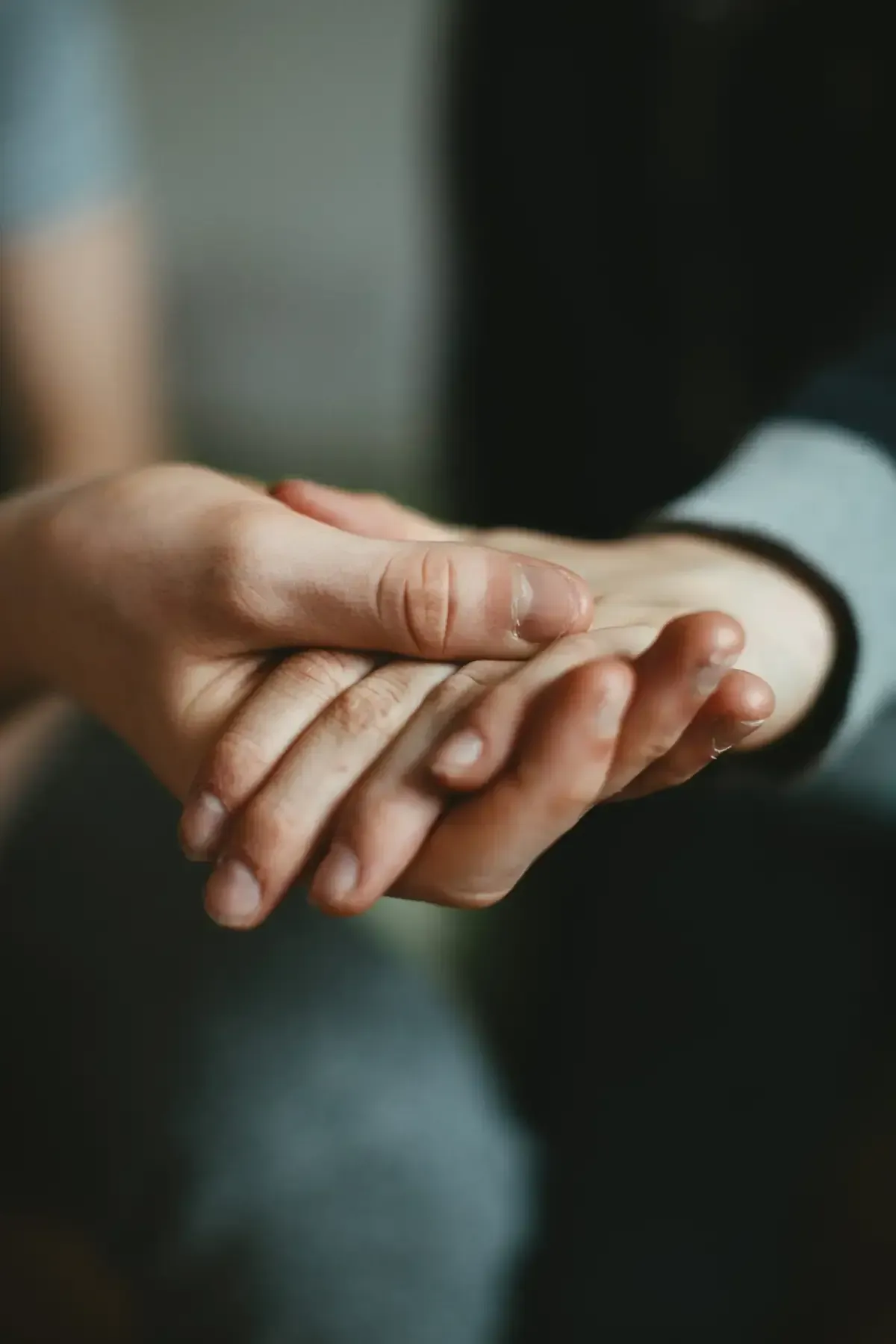 Manos juntas, una mano apoyada encima.