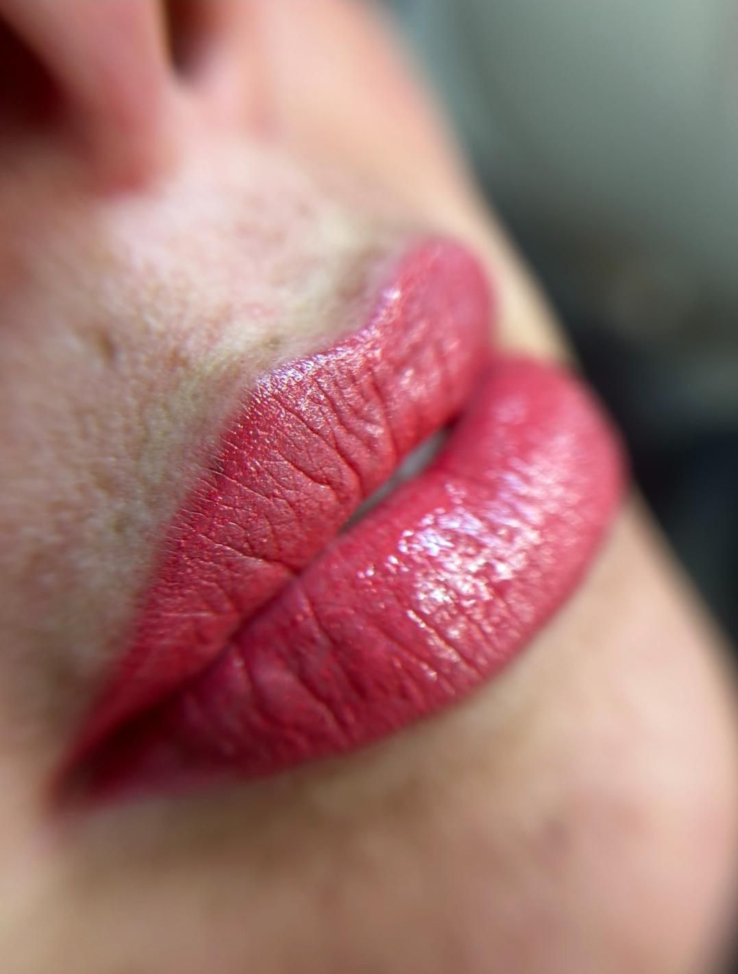 Primer plano de labios rosados ​​con textura visible, ligeramente separados.