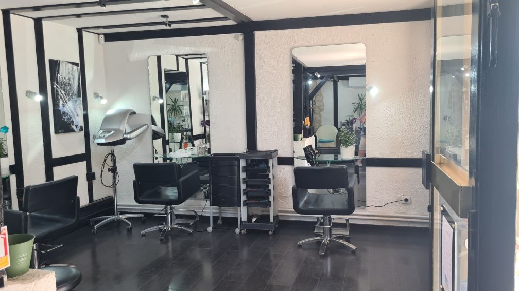 Gros plan sur une coupe de cheveux bouclés avec les côtés dégradés dans un salon de coiffure