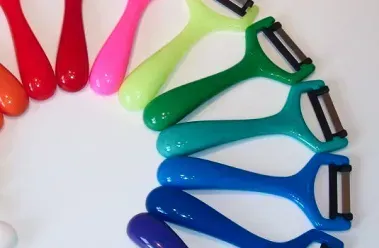 Bunte Gemüseschäler sind auf einer weißen Fläche angeordnet und erzeugen einen Regenbogeneffekt.