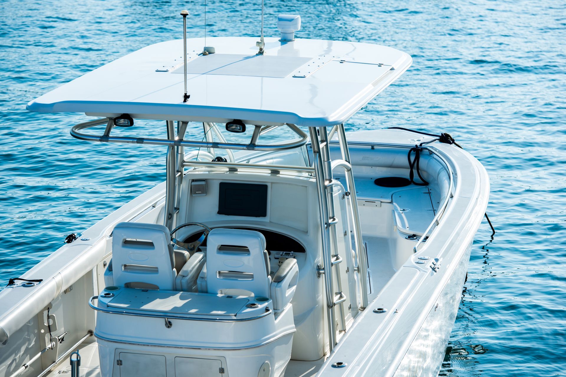Weißes Fischerboot auf blauem Wasser mit Verdeck und Sitzbereich
