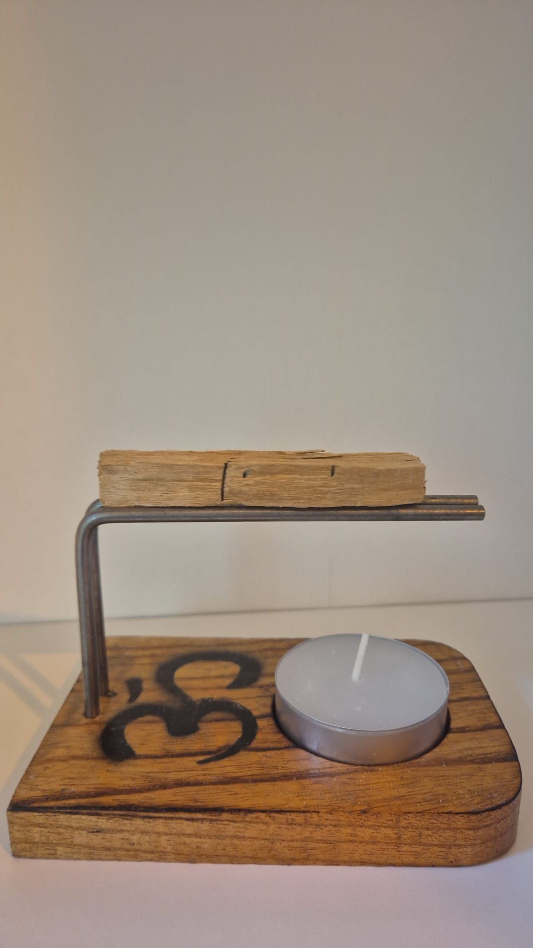 Un candelabro de madera con una vela dentro.