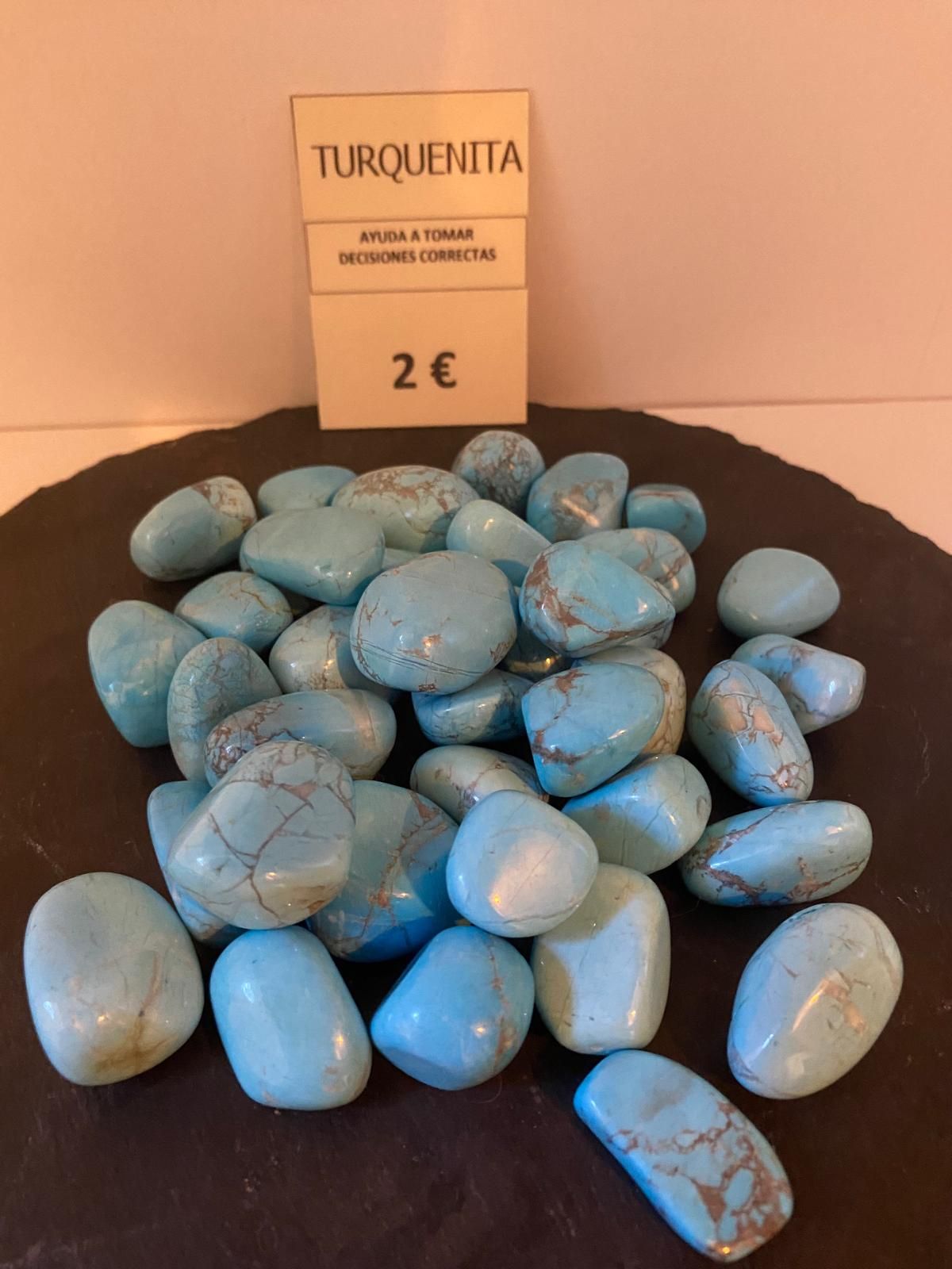 Una pila de piedras turquesas sobre una superficie negra.