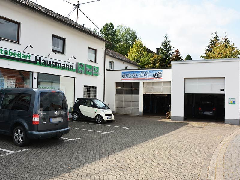 Ein Smart steht vor einer Hausmann-Garage