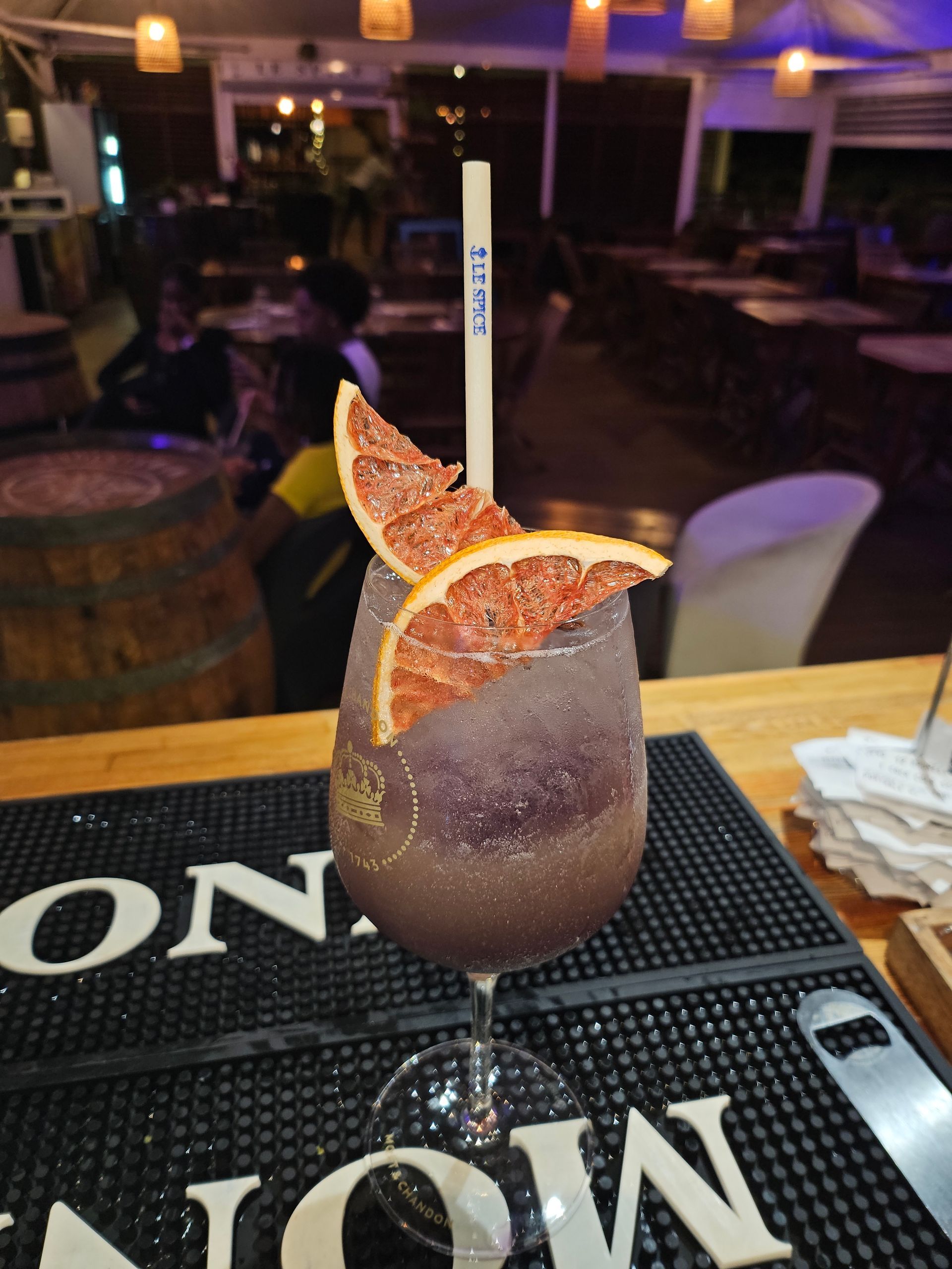 Cocktail violet avec tranches de pamplemousse.