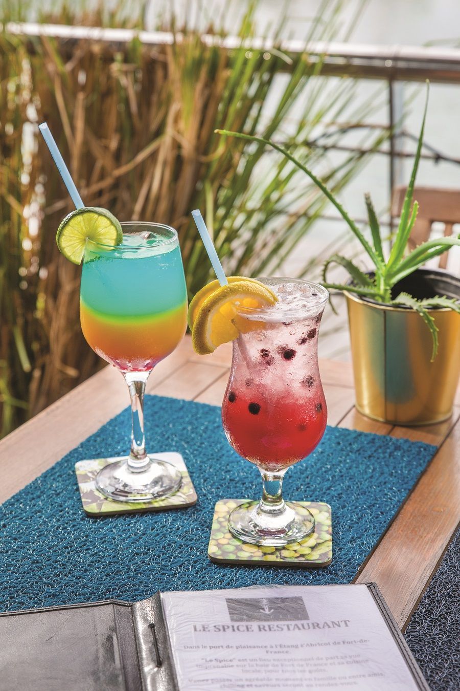 Cocktail bleu, jaune et orange avec cocktail rouge.