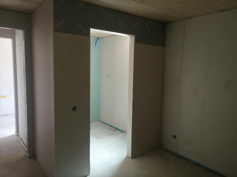 Porta interna in costruzione; cartongesso installato, aperta su un'altra stanza.