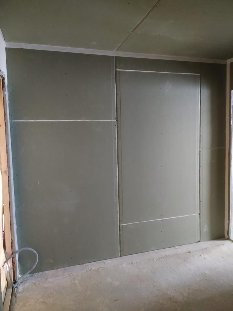 Una stanza con un grande muro e una porta al suo interno.