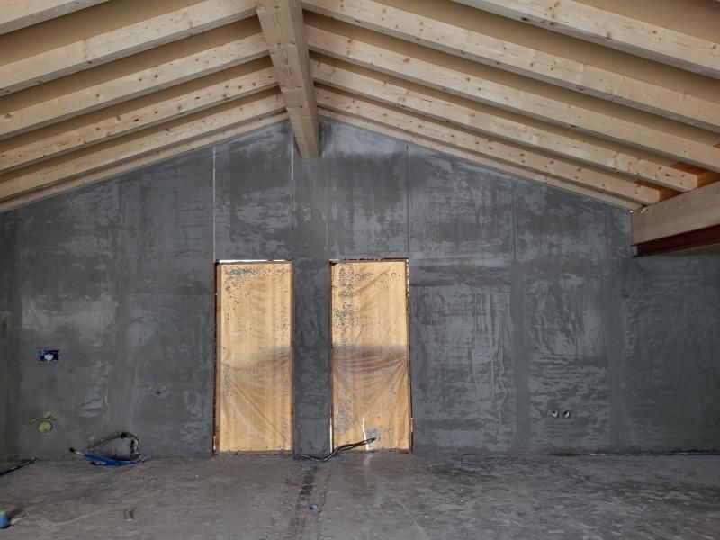 Una stanza con due porte in legno e tetto in legno.