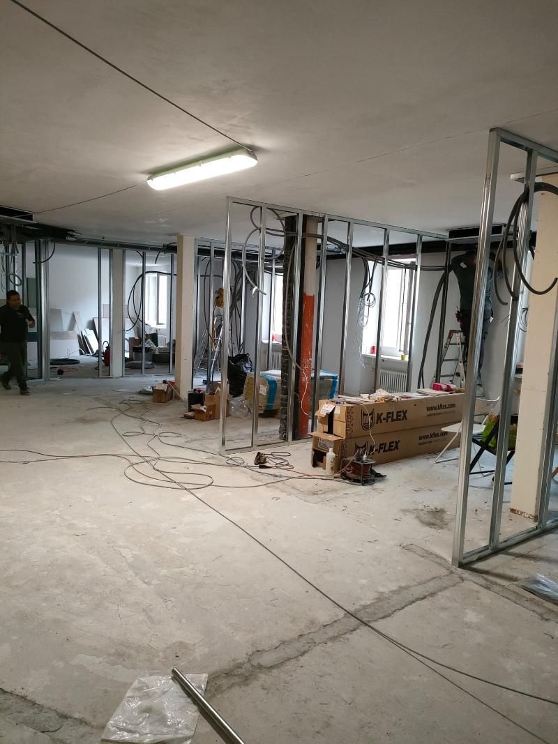 È in fase di ristrutturazione una grande stanza con molti scatoloni sul pavimento.