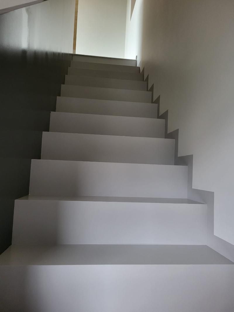 Scale dipinte di grigio che conducono verso l'alto in un interno ben illuminato.