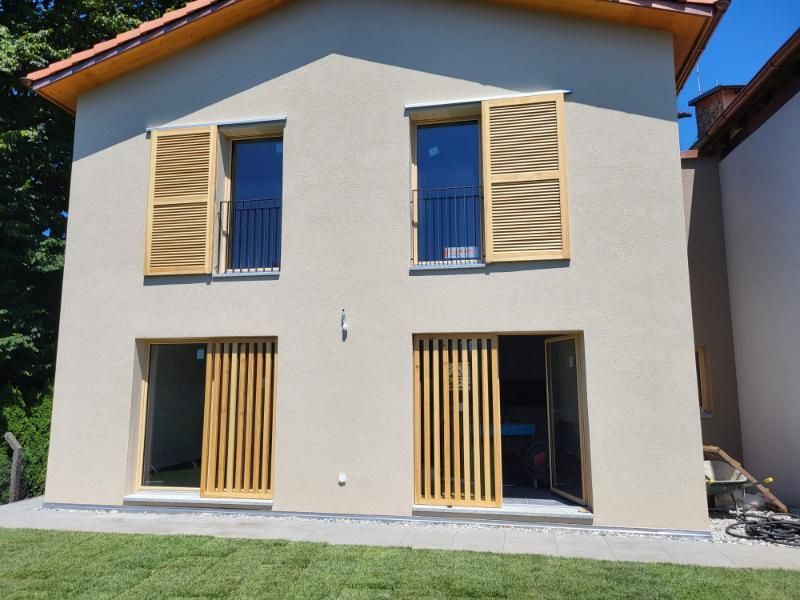 Una casa con molte finestre e persiane