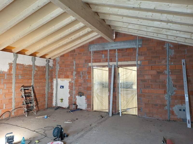 È in fase di ristrutturazione una stanza con pareti in mattoni e travi in ​​legno.