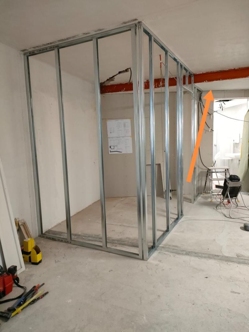 Una stanza in costruzione con una freccia rossa che punta a destra
