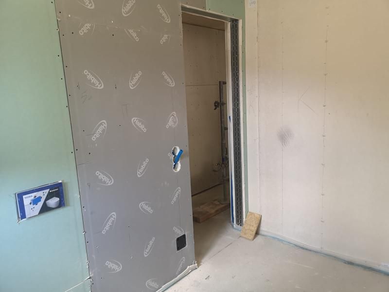 Una stanza con una porta scorrevole tra due pareti.