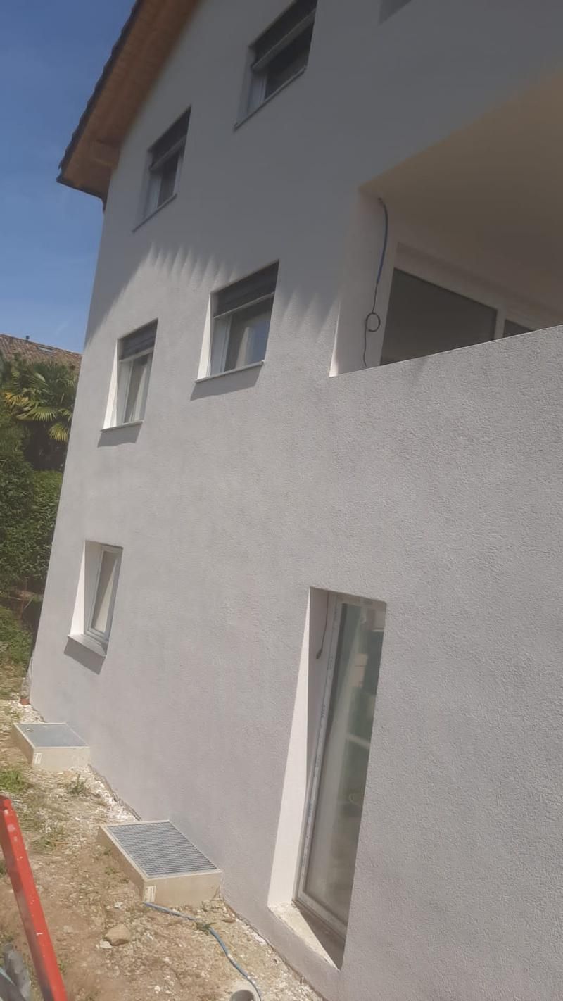 Un edificio bianco con molte finestre e un balcone.