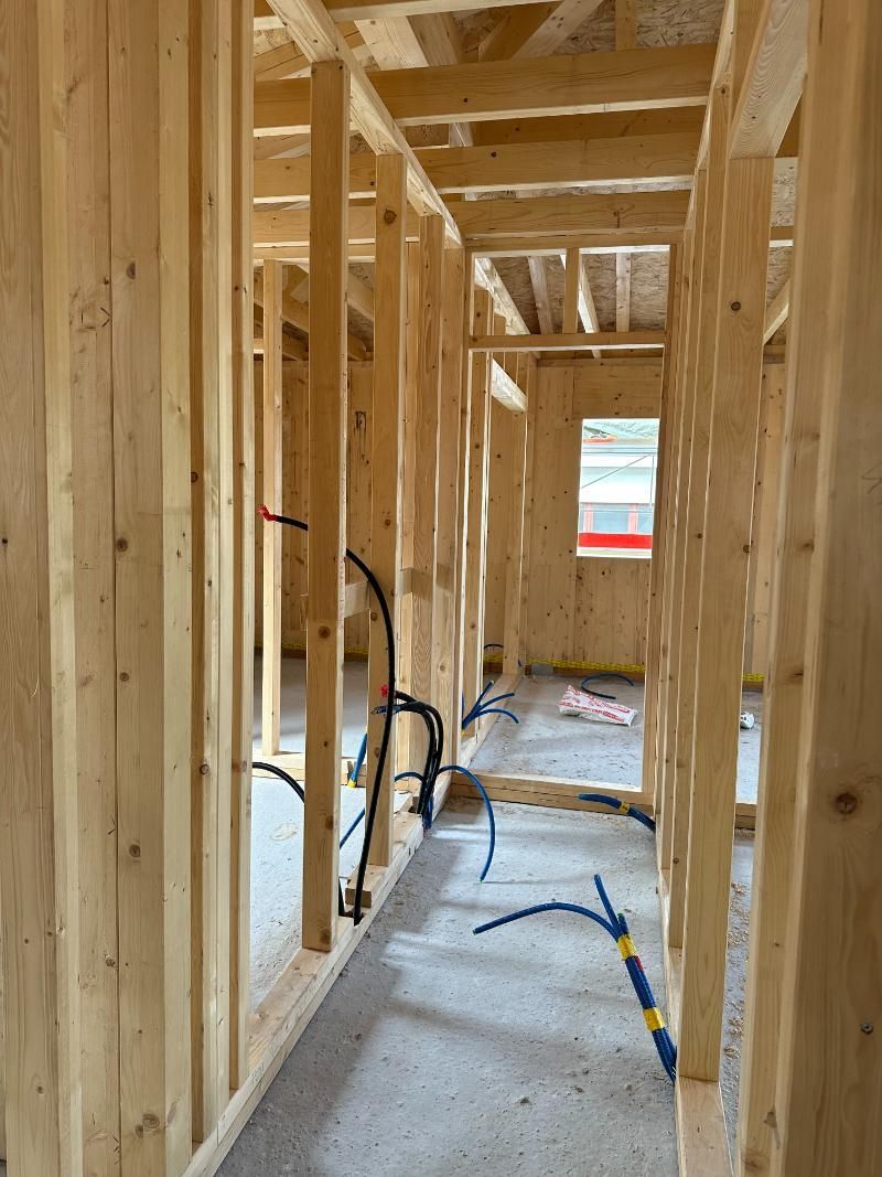 Un corridoio in una casa in costruzione con travi in ​​legno.