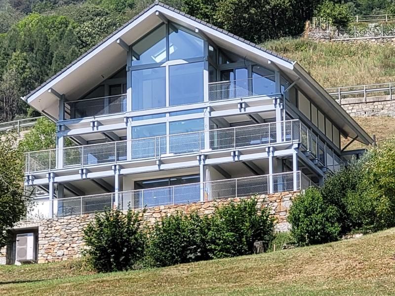 Una grande casa con molte finestre si trova in cima a una collina