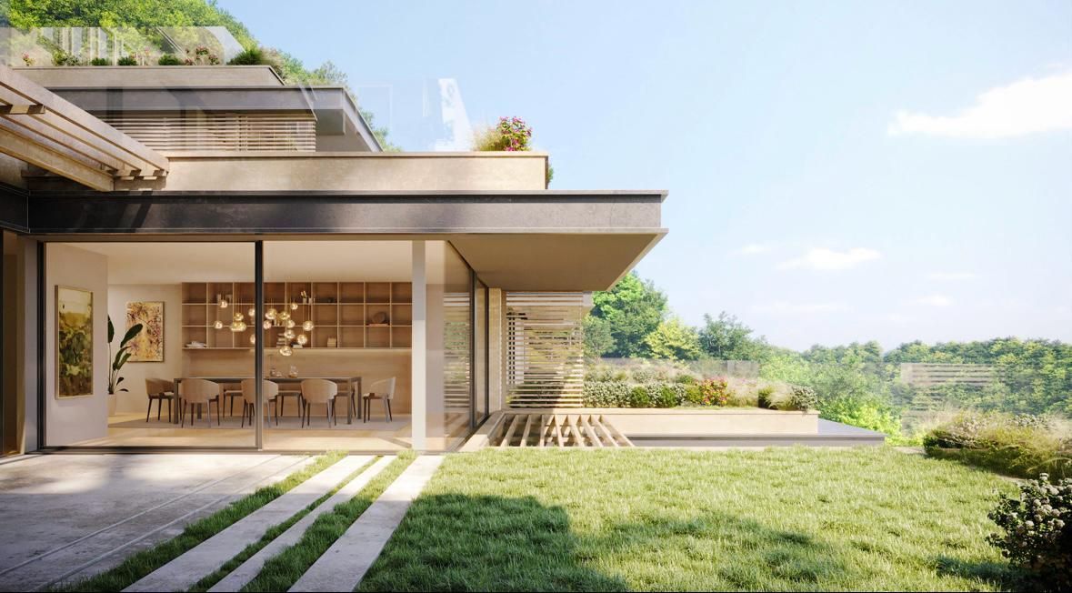 Esterno di una casa moderna con pareti in vetro che si affacciano su un prato verde e un patio.