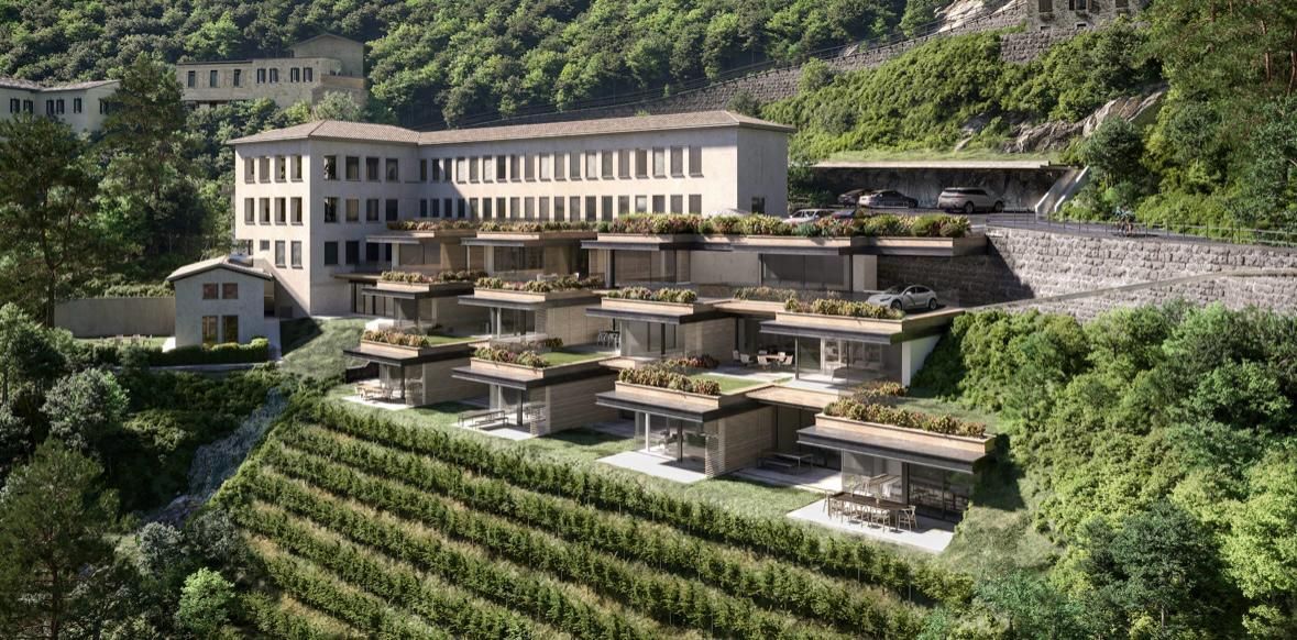 Edifici adagiati su una collina con vigneti terrazzati, circondati da una vegetazione lussureggiante.