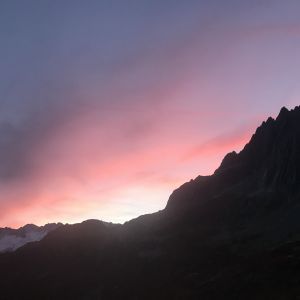 Ein Sonnenuntergang über einer Bergkette mit einem rosa Himmel