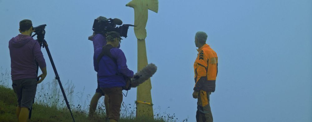 Eine Gruppe von Menschen steht nebeneinander auf einem Hügel.