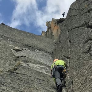 Eine Person klettert eine Felswand hinauf.