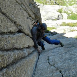 Ein Mann klettert eine Felswand hinauf.