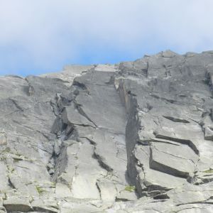 Eine große Felsklippe mit blauem Himmel im Hintergrund.