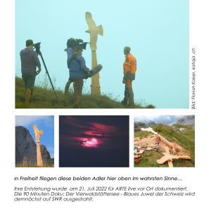 Eine Gruppe von Menschen steht vor einem Kreuz auf einem Hügel.