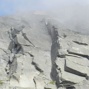 Eine Klippe mit vielen Felsen und einem blauen Himmel im Hintergrund