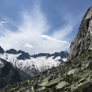 Ein mit Schnee und Felsen bedeckter Berg mit einem blauen Himmel im Hintergrund