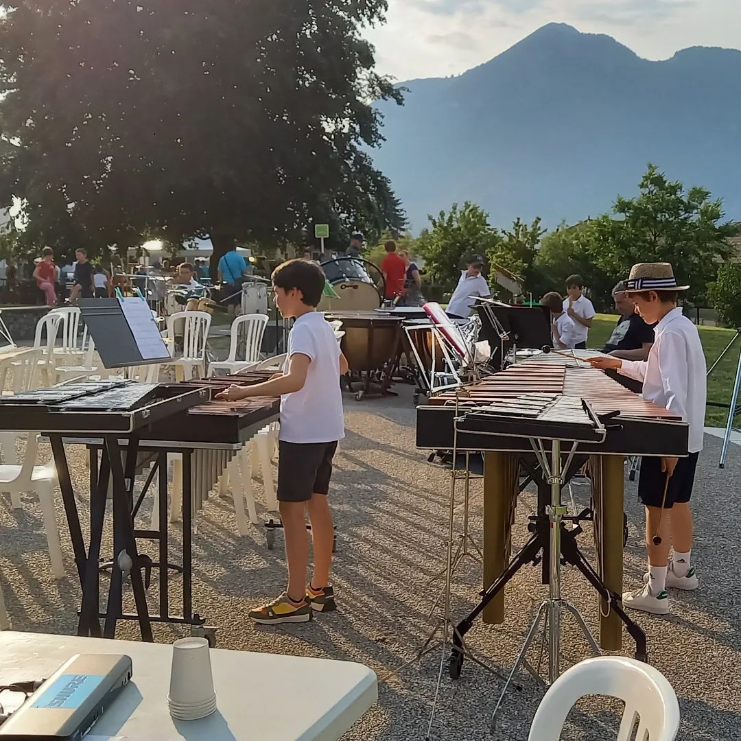 Deux enfants jouent d'un instrument devant un public