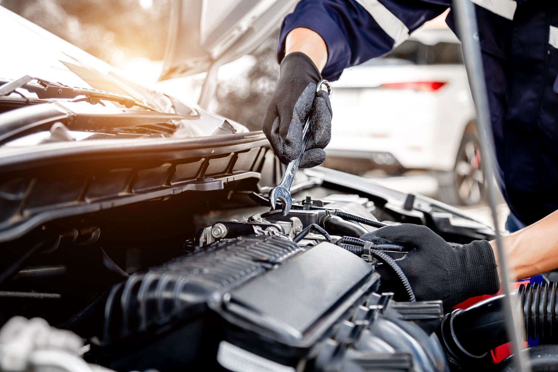 Un mécanicien utilise un outil sur un moteur de voiture