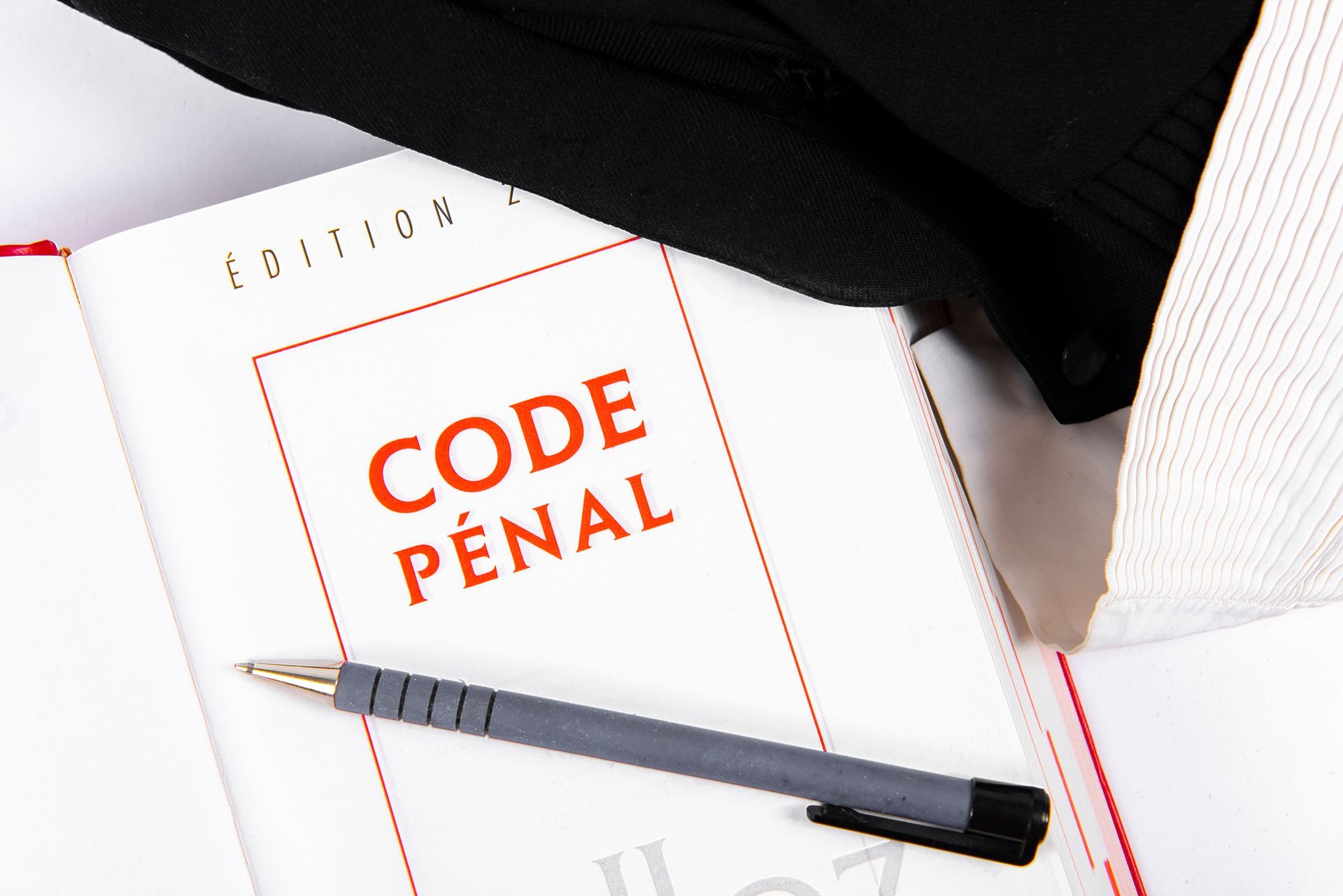 Page de garde du Code pénal où est posé un stylo.