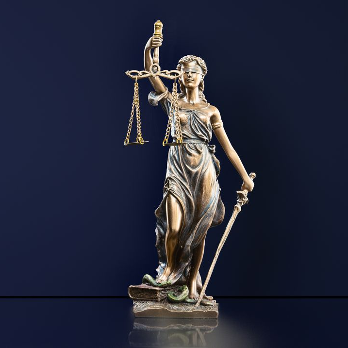 Statue en bronze de la Justice avec une balance et une épée, les yeux bandés.