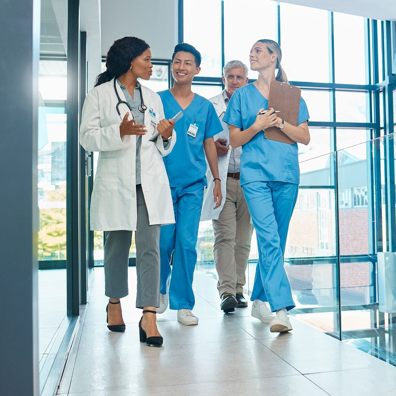 Une équipe médicale se promène et discute dans un couloir d'hôpital.