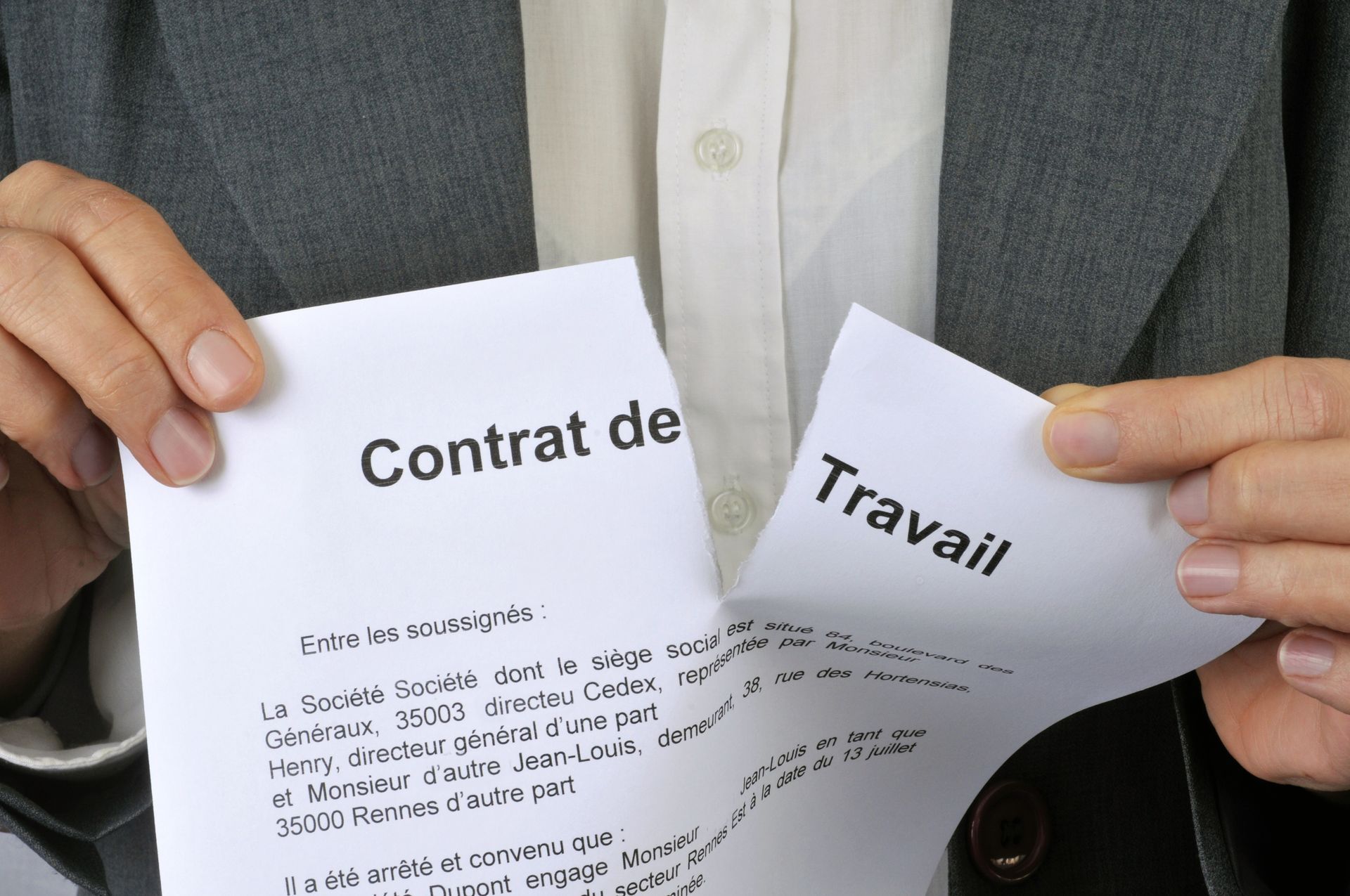 Une personne déchire un contrat de travail.