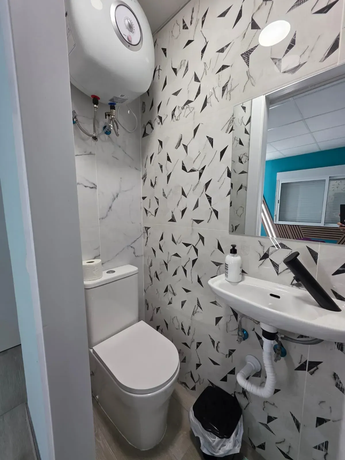 Un baño con inodoro, lavabo y espejo.