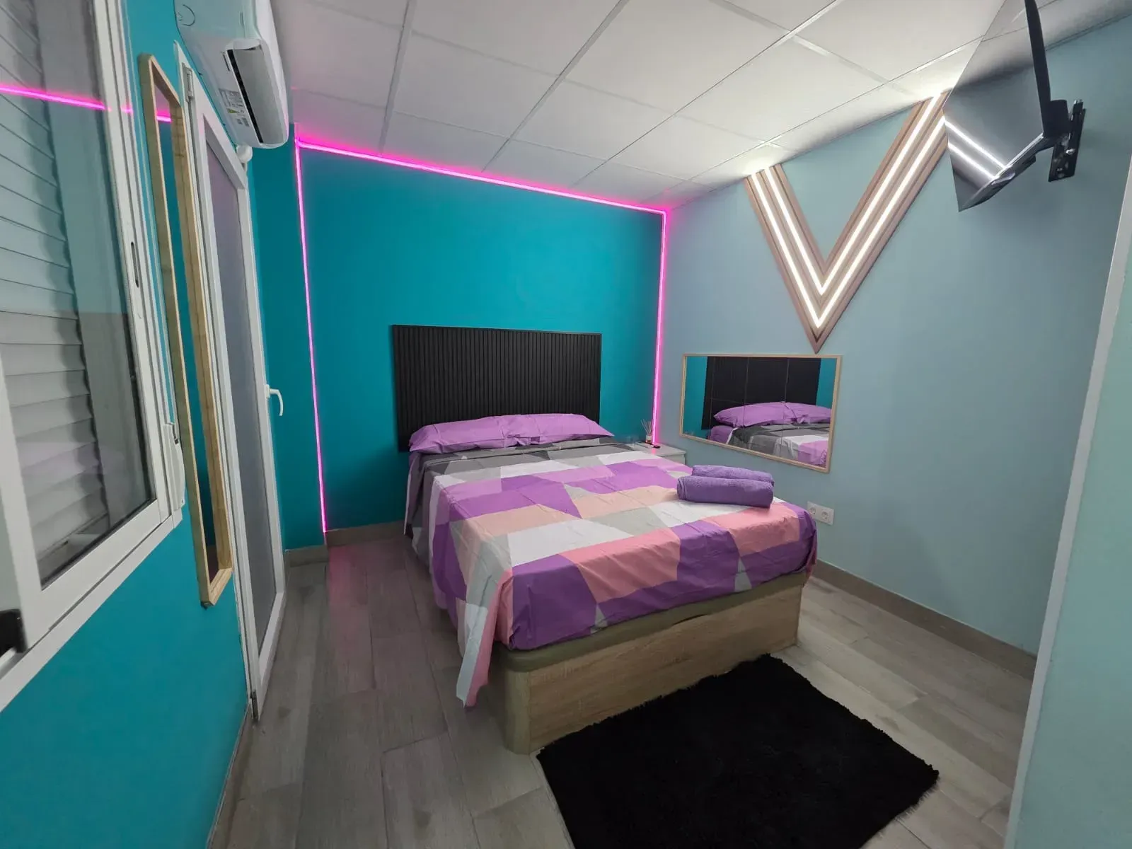 Un dormitorio con una cama y un espejo en la pared.