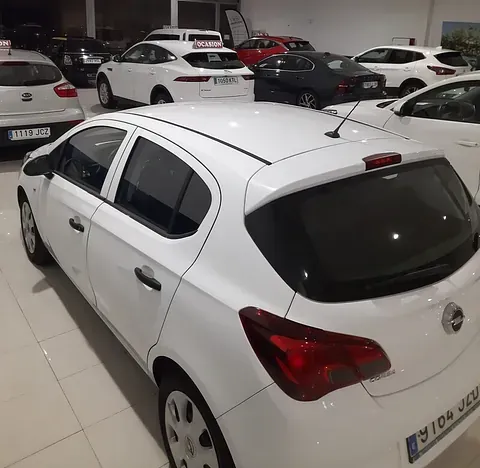 Una fila de coches blancos están aparcados en una sala de exposición.