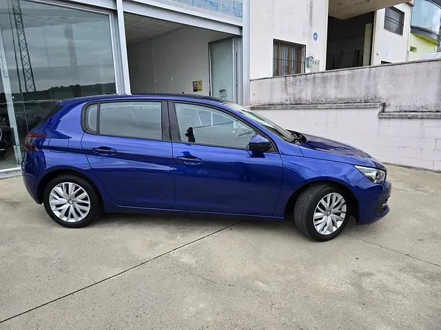 Un coche azul está aparcado delante de un edificio.