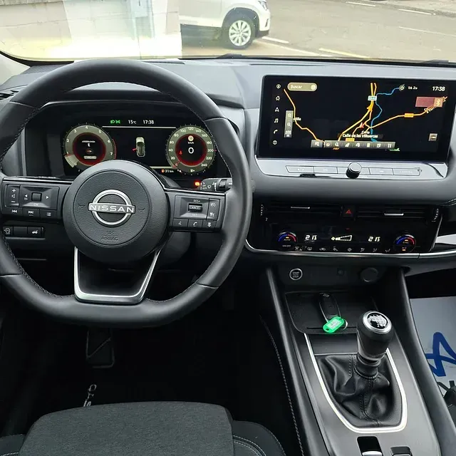 El interior de un coche Nissan con volante y tablero.