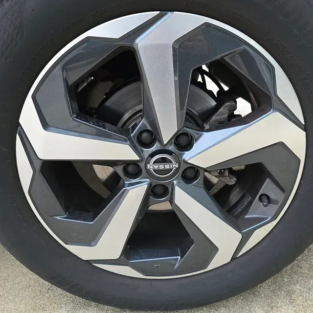 Un primer plano de una rueda Nissan en un coche.